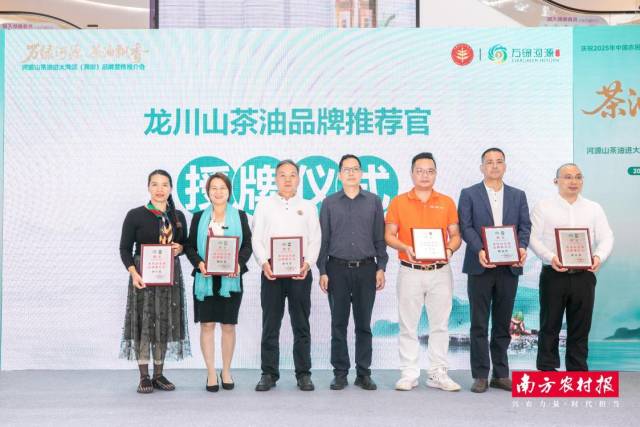 河源市龙川县农业农村局党组书记、局长黄海龙为龙川县山茶油品牌推荐官授牌。